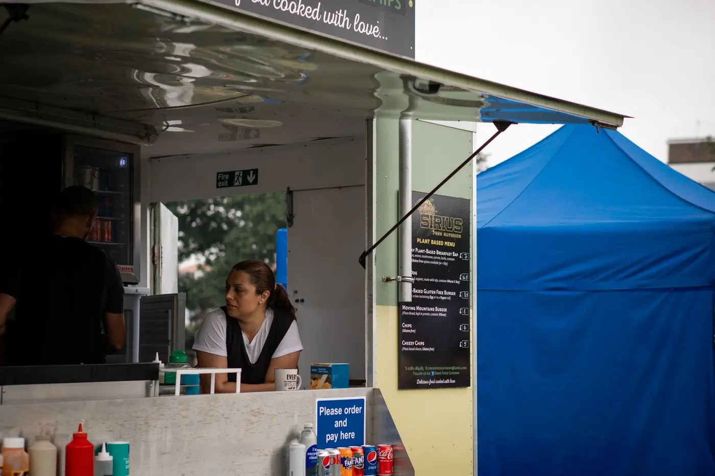 A food truck service window with its menu board beside it